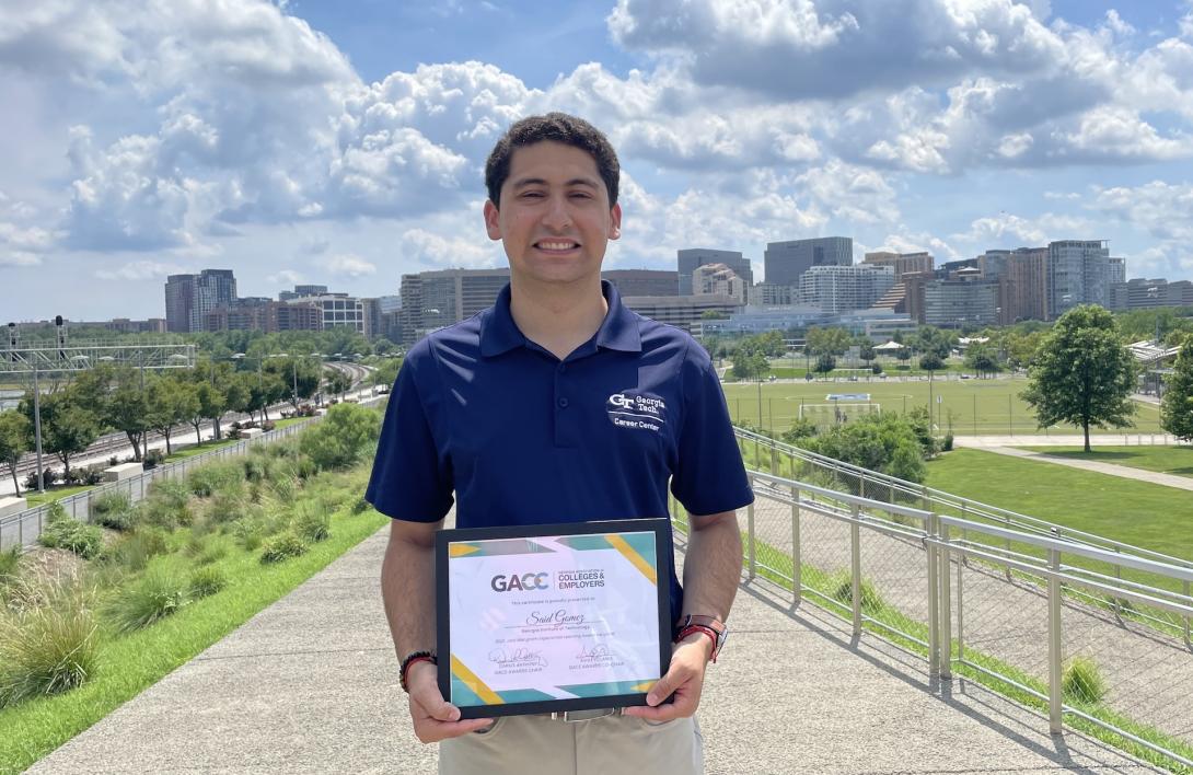 Said Gomez holding the Jack Mangham Experiential Learning Award. 